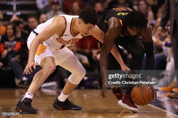 Devin Booker of the Phoenix Suns and John Holland of the Cleveland Cavaliers reach for a loose ball during the second half of the NBA game at Talking...