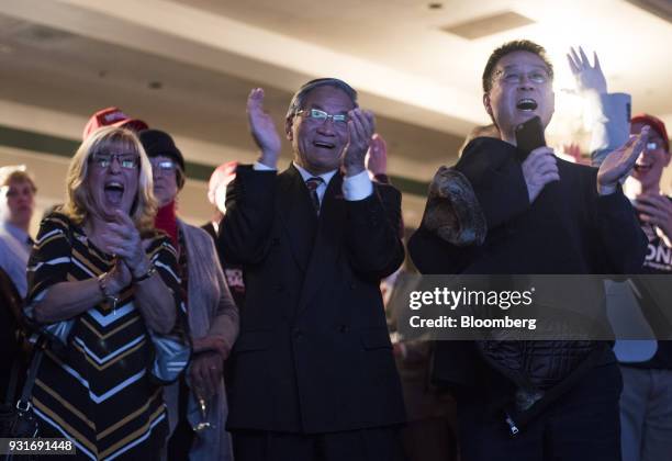 Attendees applaud and cheer while watching polling results during an election night rally with Rick Saccone, Republican candidate for the U.S. House...