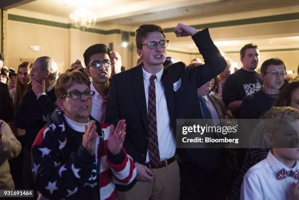 Attendees applaud and cheer while watching polling results during an election night rally with Rick Saccone, Republican candidate for the U.S. House...