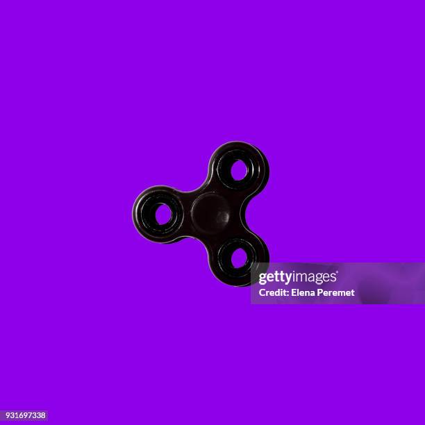 black spinner on a purple background - gegengift stock-fotos und bilder