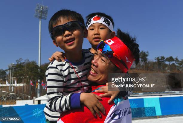 Yoshihiro Nitta of Japan celebrates his 2nd place with his children after a victory ceremony of the men's 1.5km sprint classic standing cross-country...