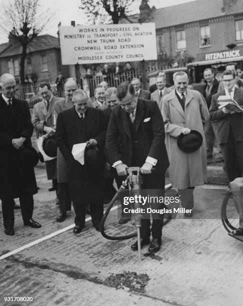 John Boyd-Carpenter , the Minister of Transport and Civil Aviation uses a pneumatic drill to inaugurate the construction of the trunk road section of...