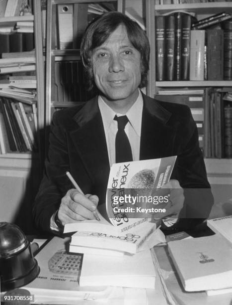 French writer Jean Carrière signs copies of his book 'L'Épervier de Maheux', for which he won the Prix Goncourt, France, 20th November 1972.