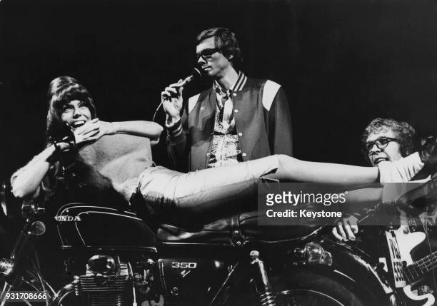 American vocal duo The Carpenters, brother and sister Richard and Karen Carpenter, in concert with a Honda motorcycle as a prop during their UK tour,...