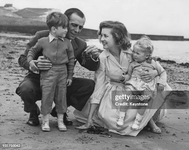 English actor and comedian Max Wall on the beach at Saltdean, Sussex, with his girlfriend, former Miss Great Britain Jennifer Chimes and her children...