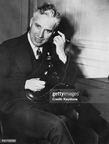 English actor and filmmaker Charlie Chaplin on the telephone in his New York hotel room, circa 1940. He is speaking to George Mitre of 'La Nacion' in...