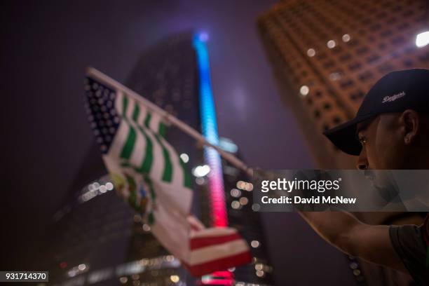 Protester waves a flag composed of elements of the U.S. And Mexican flags in front of the InterContinental Los Angeles Downtown hotel where U.S....