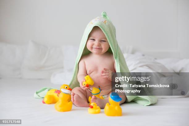 cute little baby toddler boy, playing with rubber ducks after bath in bed - diaper boy fotografías e imágenes de stock