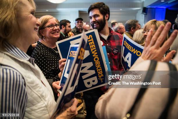 Volunteers pass posters at the Hilton Garden Inn Pittsburgh-Southpointe where a watch party is being held for Democrat candidate Conor Lamb during...