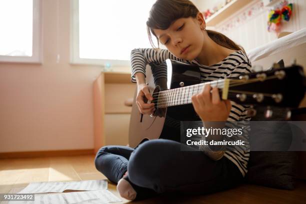 teenage girl practicing guitar - plucking an instrument stock pictures, royalty-free photos & images