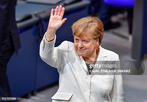 German Chancellor Angela Merkel waves as she arrives to attends the session for the election of the German Chancellor at the Bundestag on March 14,...