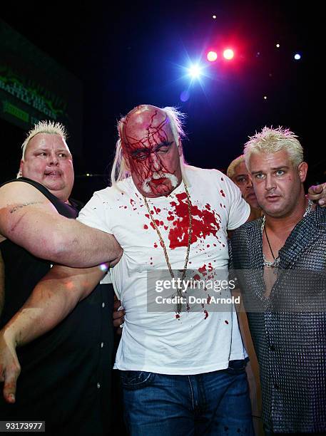 Hulk Hogan is escorted to a backstage area by Brian Knobbs and Brutus Beefcake after an altercation involving Ric Flair during a press conference for...