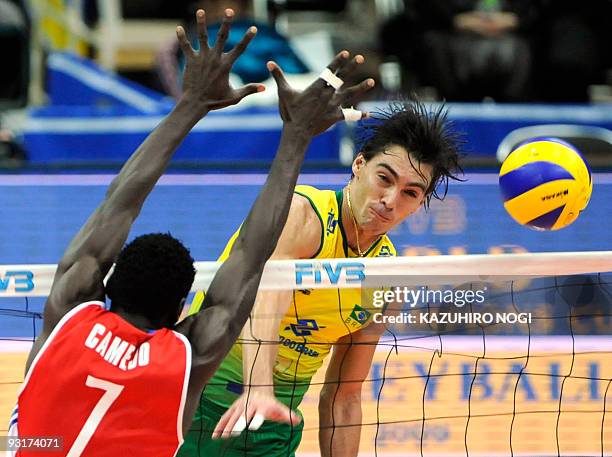 Brazil's captain Gilberto Godoy Filho "Giba" spikes the ball past Cuba's Osmany Camejo Durruty during the men's grand championship cup volleyball in...
