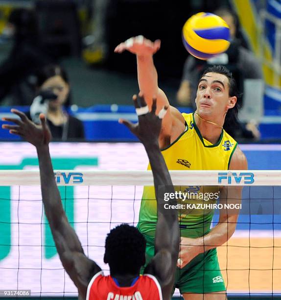 Brazil's captain Gilberto Godoy Filho "Giba" spikes the ball over Cuba's Osmany Camejo Durruty during the men's grand championship cup volleyball in...