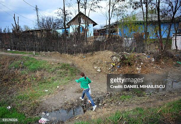 Isabelle Wesselingh A girl jumps walks in the village of Raducaneni, 350km northeast from Bucharest on November 12, 2009. Constantin was left in the...