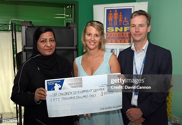 Emma Stenson a trustee of the European Tour Wives Association and Jonathan Orr, Trustee of the Tour Players Foundation poresent Shafia Bari the...