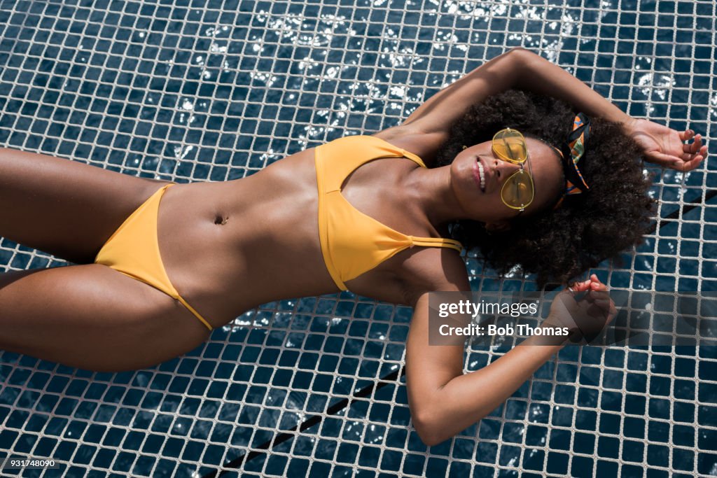 Mixed Race Woman Sunbathing on a Luxury Yacht