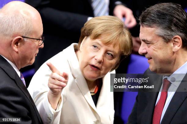 German Chancellor Angela Merkel chats with Social Democrat and outgoing Foreign Minister Sigmar Gabriel and Christian Democrat Volker Kauder during...