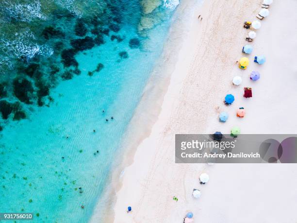 beach umbrellas and blue ocean. beach scene from above - indonesia aerial stock pictures, royalty-free photos & images