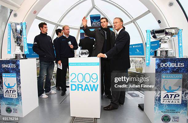 Mike Bryan of USA draws a name from the pot with doubles partner Bob Bryan of USA and Andy Murray of Great Britain looking on at the Barclays ATP...