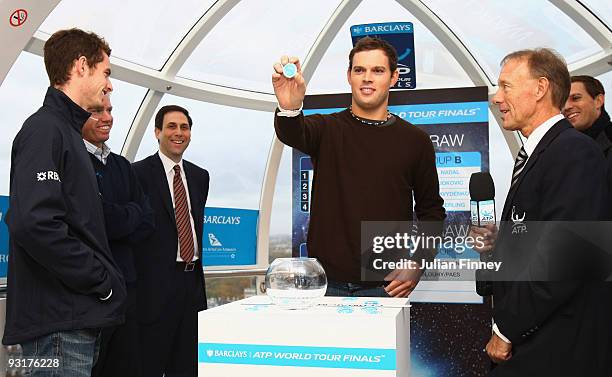 Bob Bryan of USA draws a name from the pot with doubles partner Mike Bryan of USA and Andy Murray of Great Britain looking on at the Barclays ATP...