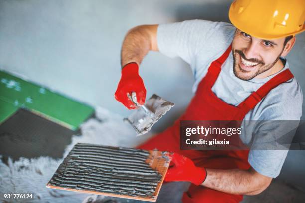 handyman installing ceramic tiles. - handyman smiling stock pictures, royalty-free photos & images