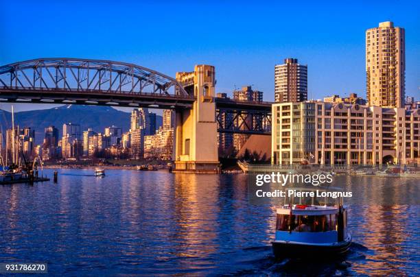 little shuttle called “aquabus” leaving granville island to cross fallscreek and reach the west end neighborhood of vancouver behind burrard bridge - granville island market foto e immagini stock