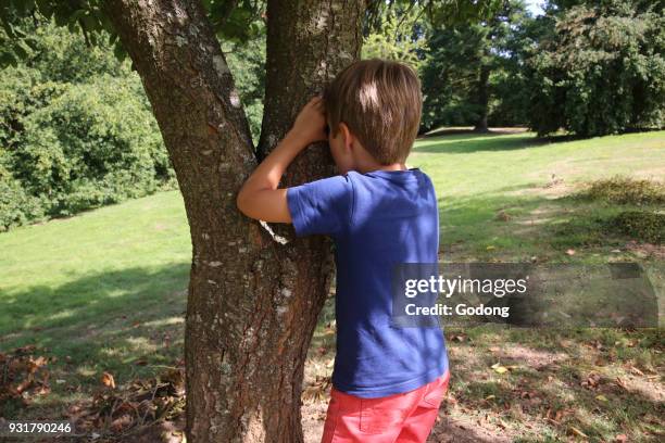 Boy playing hide and seek. France.