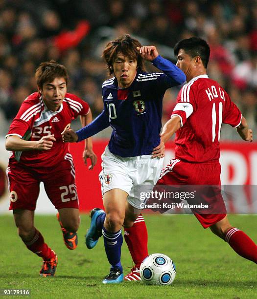 Shunsuke Nakamura of Japan and Li Haiqiang and Wong Chin Hung of Hong Kong compete for the ball during AFC Asia Cup 2011 Qatar qualifier match...