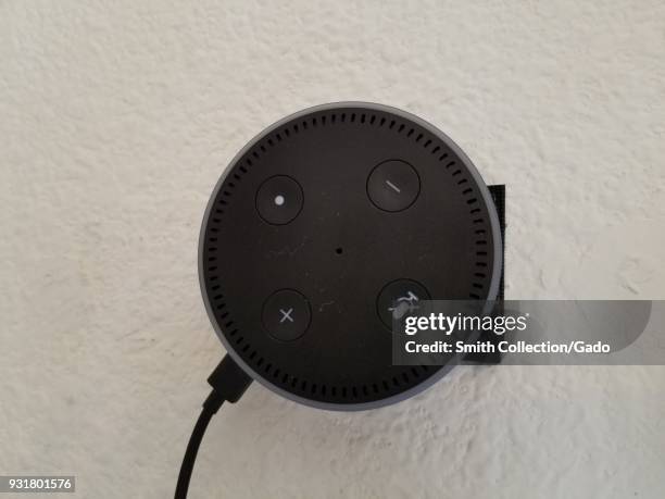 Close-up of Amazon Echo Dot affixed to a stucco wall using Velcro, a voice assistant using the Alexa system from Amazon.com, March 5, 2018.