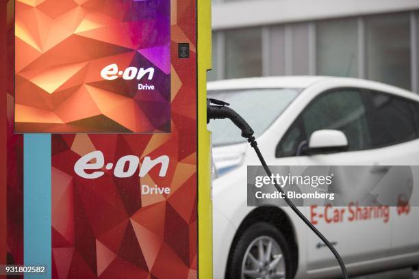 An electric automobile sits at a charging station outside the headquarters of EON SE in Essen, Germany, on Tuesday, March 13, 2018. EON will shed as...