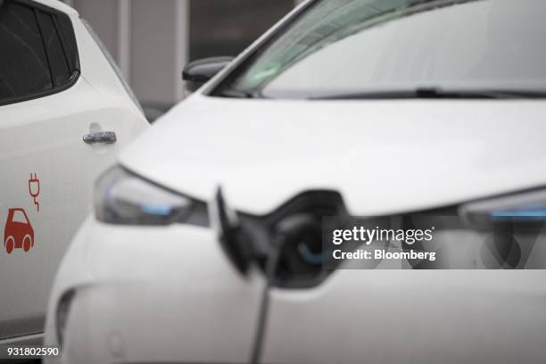 Cable charges an electric automobile at a charging station outside the headquarters of EON SE in Essen, Germany, on Tuesday, March 13, 2018. EON will...