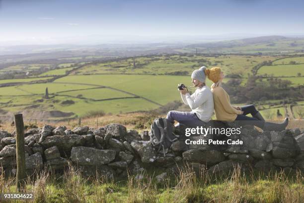 hiking couple resting on stone wall - bodmin moor stock pictures, royalty-free photos & images