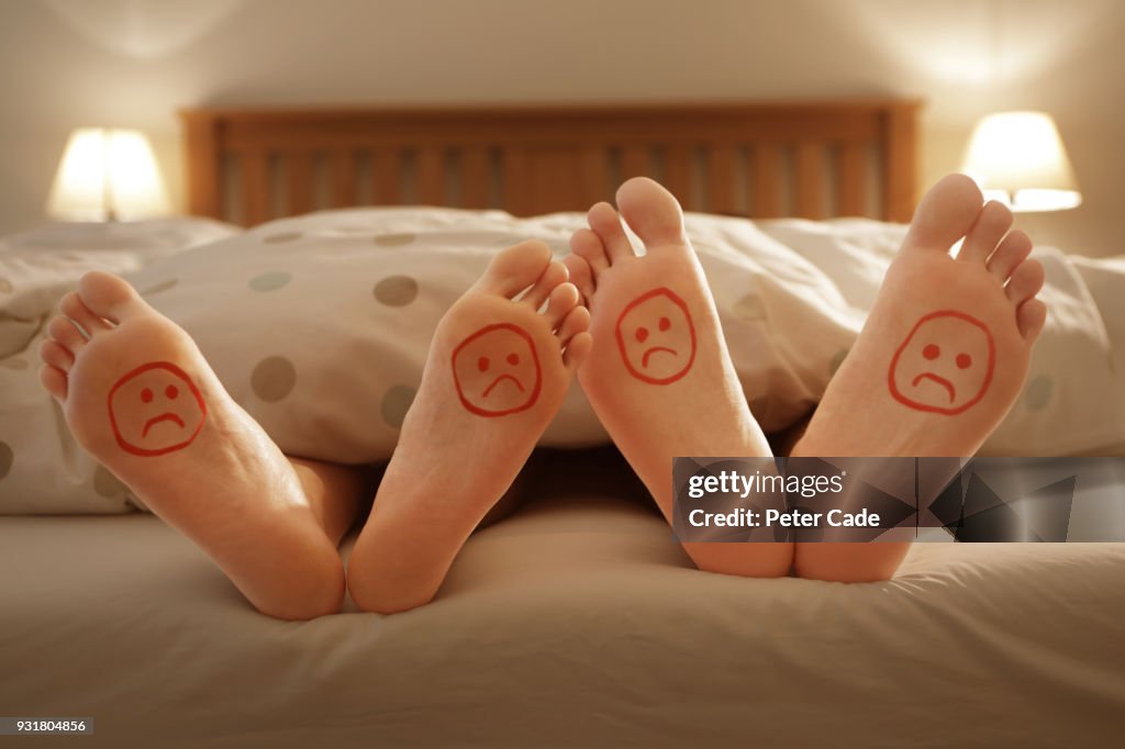 Couples unhappy feet in bed