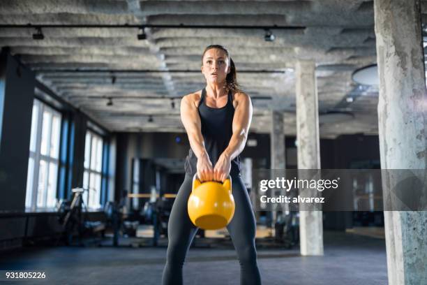 donna sportiva che fa oscillazioni kettlebell in palestra - altalena foto e immagini stock