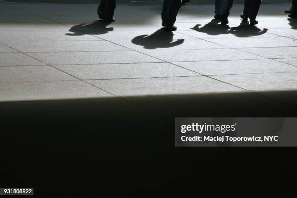 view of people feet and their shadows on a sidewalk. - busy sidewalk stock pictures, royalty-free photos & images