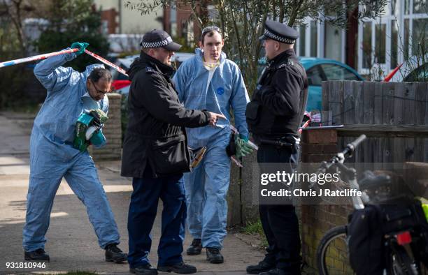 Police forensics officers carry a shovel and other gardening tools into a forensics tent outside the home of Russian exile Nikolai Glushkov who was...