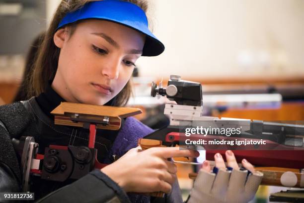 vrouw met een sportieve pistool schietklaar - luchtgeweer sportartikelen stockfoto's en -beelden