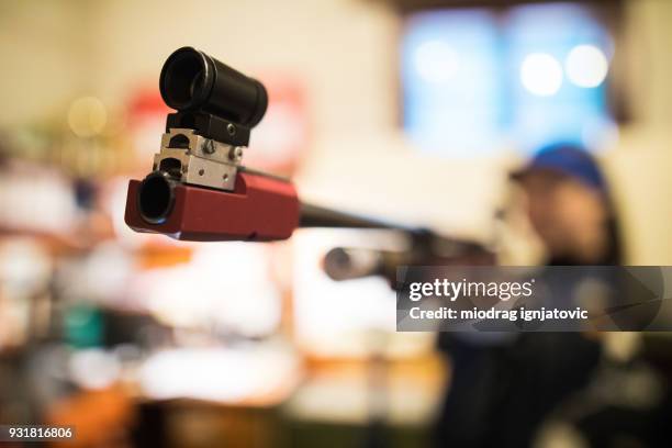 a woman pointing a sporting gun at the camera - air-gun stock pictures, royalty-free photos & images