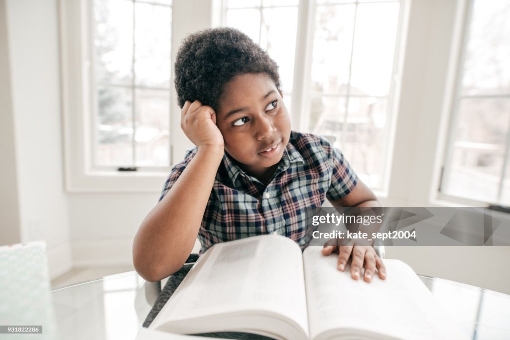 8 years old boy doing homework in a domestic kitchen
