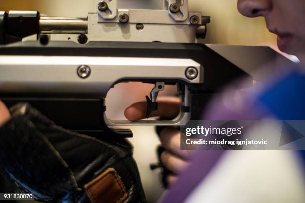 woman with a gun ready to shoot on target - air gun stock pictures, royalty-free photos & images