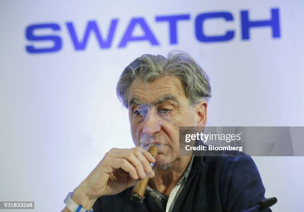 Nick Hayek, chief executive officer of Swatch Group AG, smokes a cigar during a news conference to announce the company's full year results in Biel,...