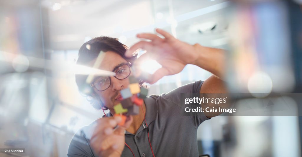 Focused, innovative male entrepreneur examining prototype