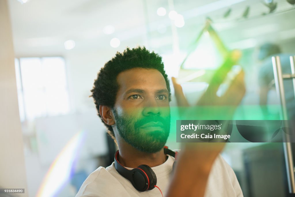 Innovative male entrepreneur examining glass cube prototype