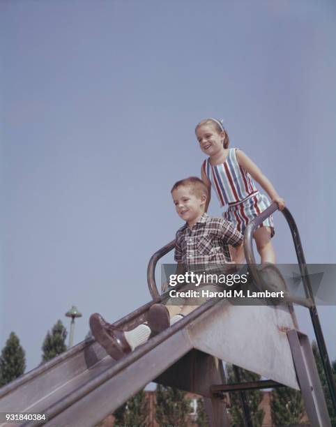 Girl with brother playing on slide