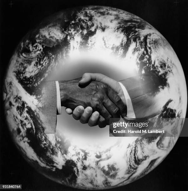 Business partners shaking hands with planet earth in background