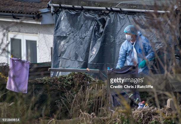 Police forensics officers erect a tarpaulin sheet over the rear of the home of Russian exile Nikolai Glushkov who was found dead at his home in New...