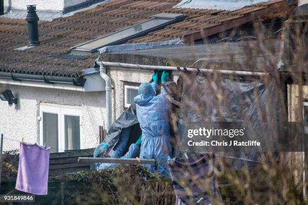 Police forensics officers erect a tarpaulin sheet over the rear of the home of Russian exile Nikolai Glushkov who was found dead at his home in New...