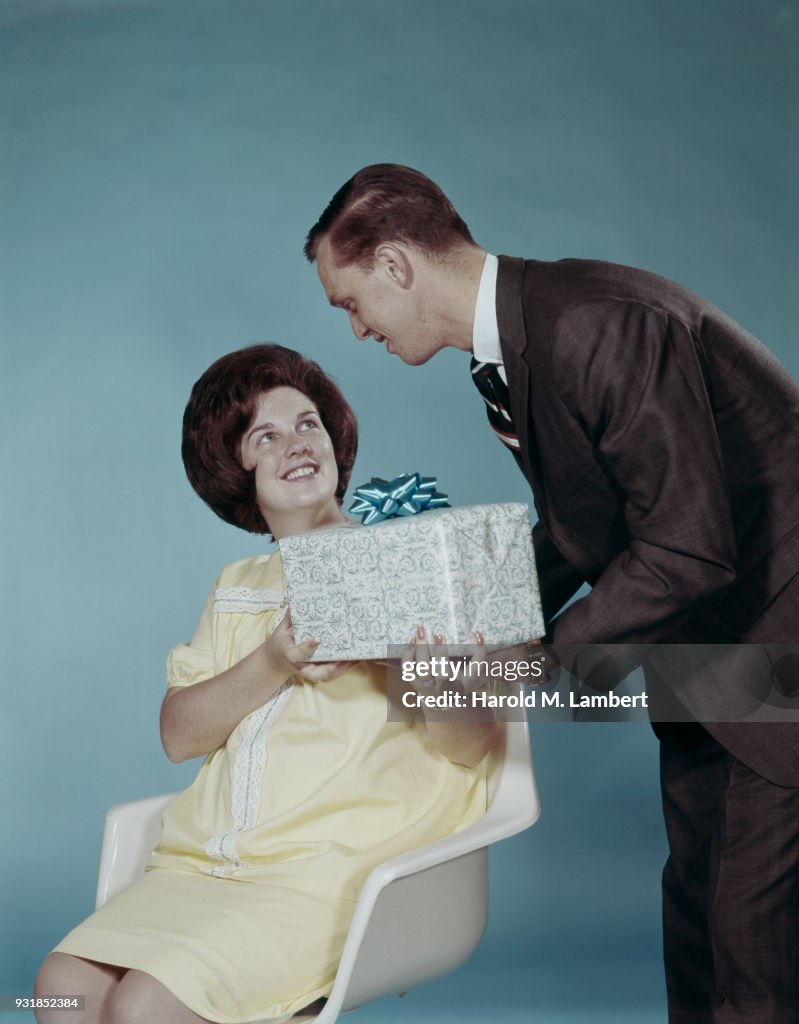 Man giving gift to woman, smiling