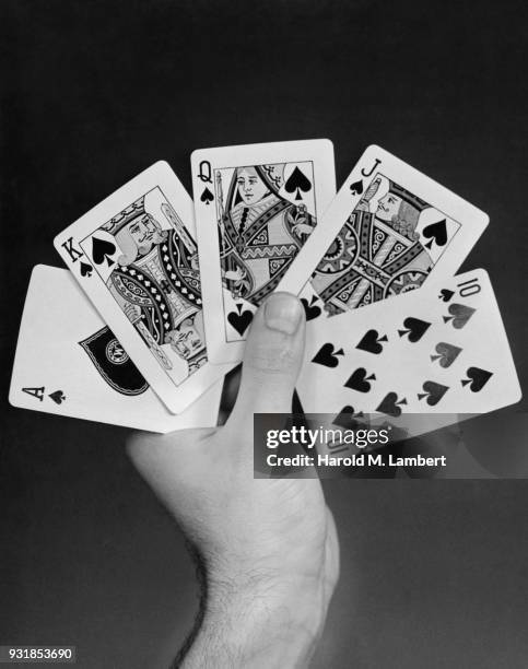 Close-up of man holding royal straight flush